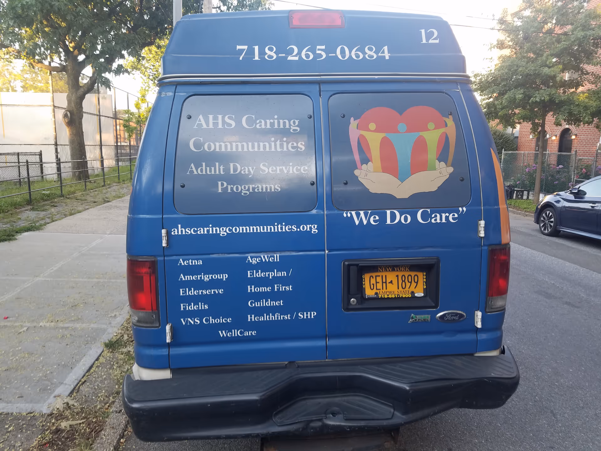 Rear view of a blue van with AHS Caring Communities signage and We Do Care slogan.