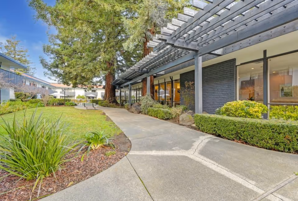 Exterior view of Easy Care Residential with a shaded walkway and landscaped greenery.