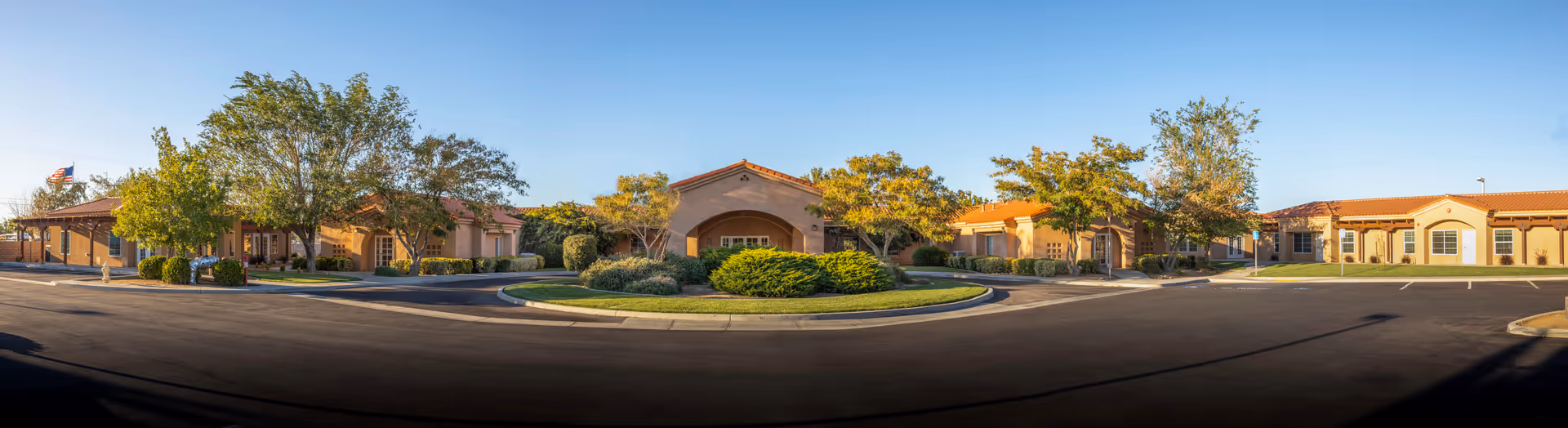 A panoramic view of Casa Colina at Apple Valley showing the building front and landscaped entrance.
