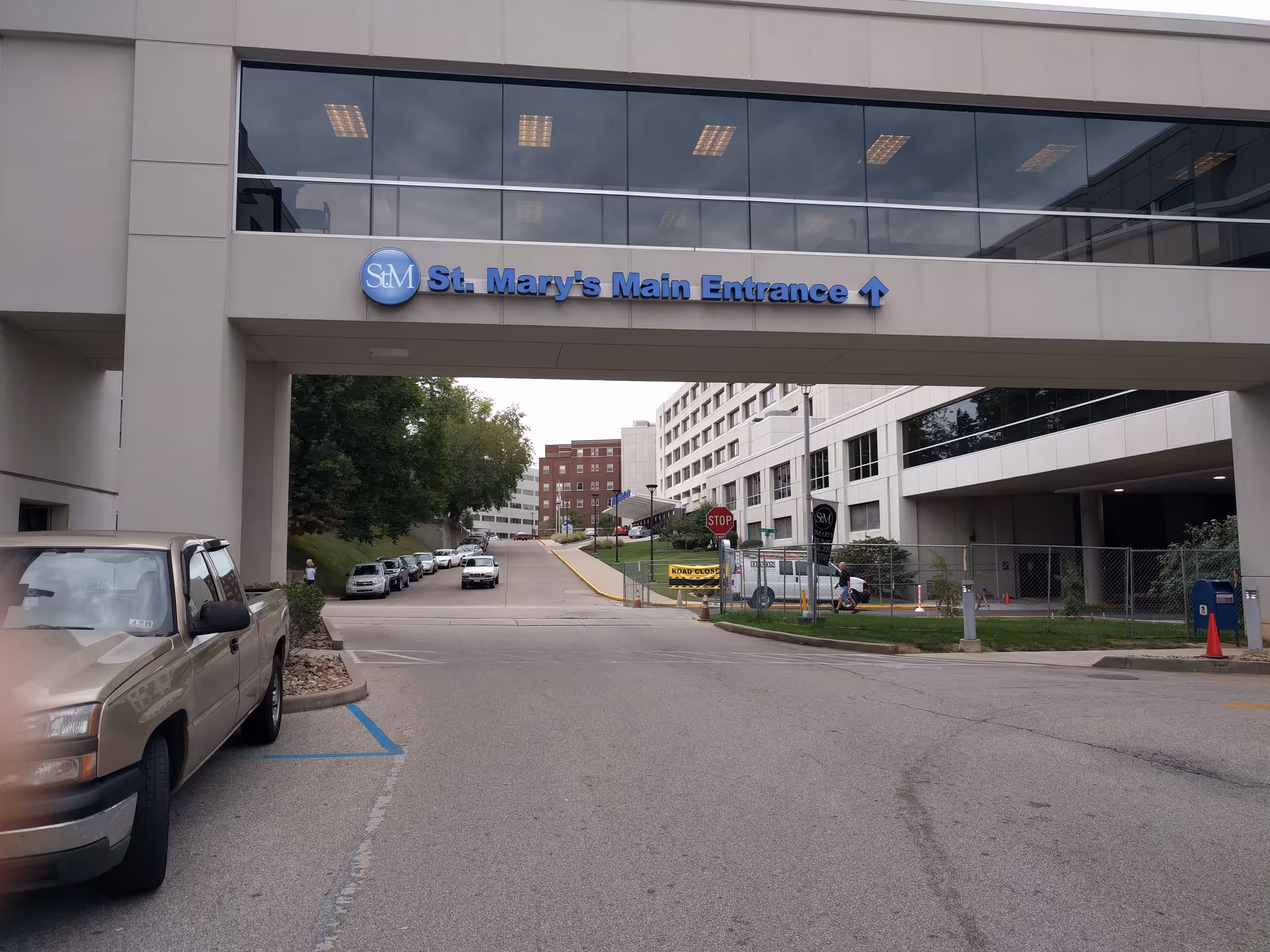 Exterior view of St. Mary's Main Entrance with cars and a pedestrian bridge.