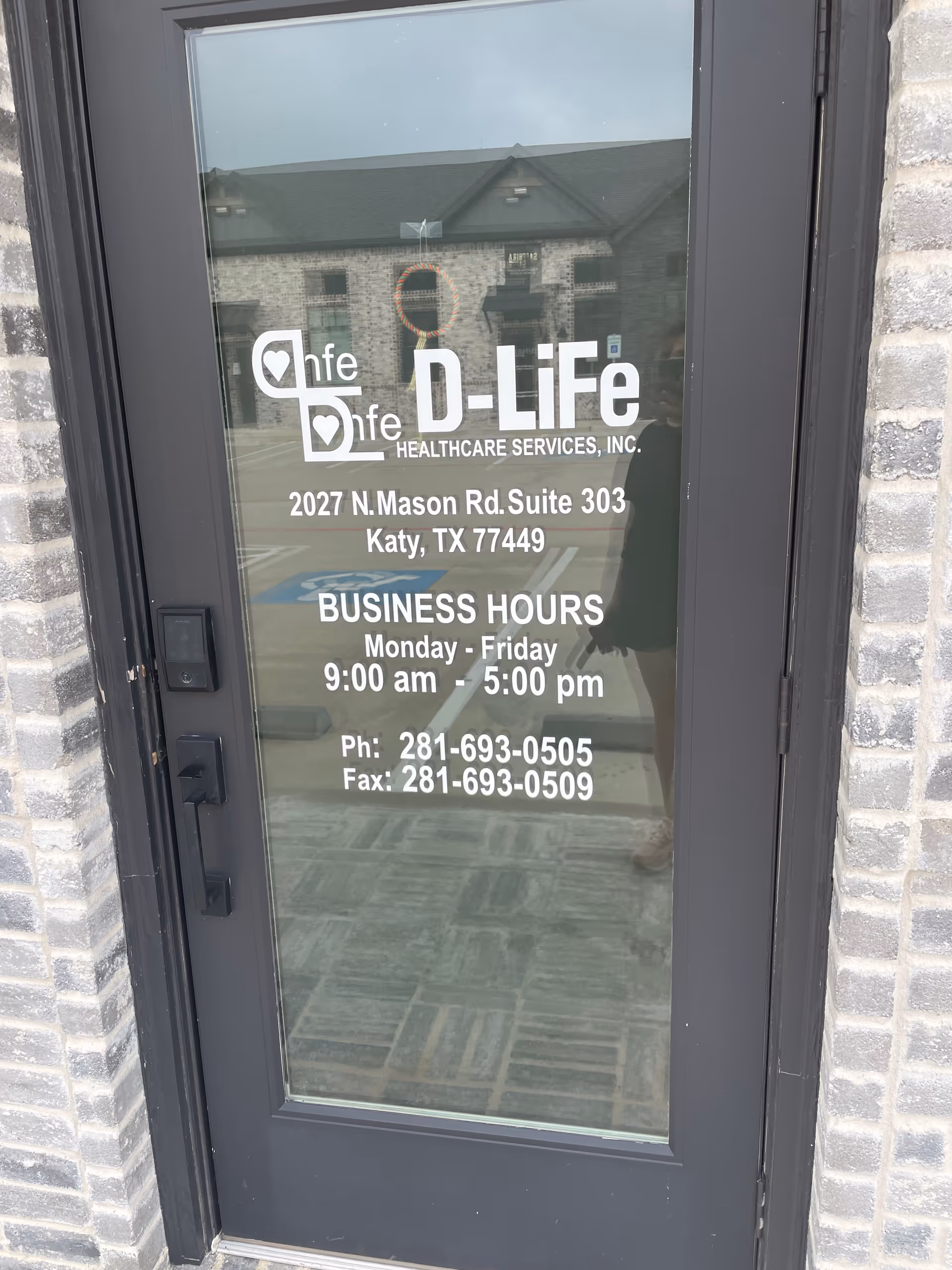 Glass entrance door displays D-Life Healthcare Services branding and business hours.