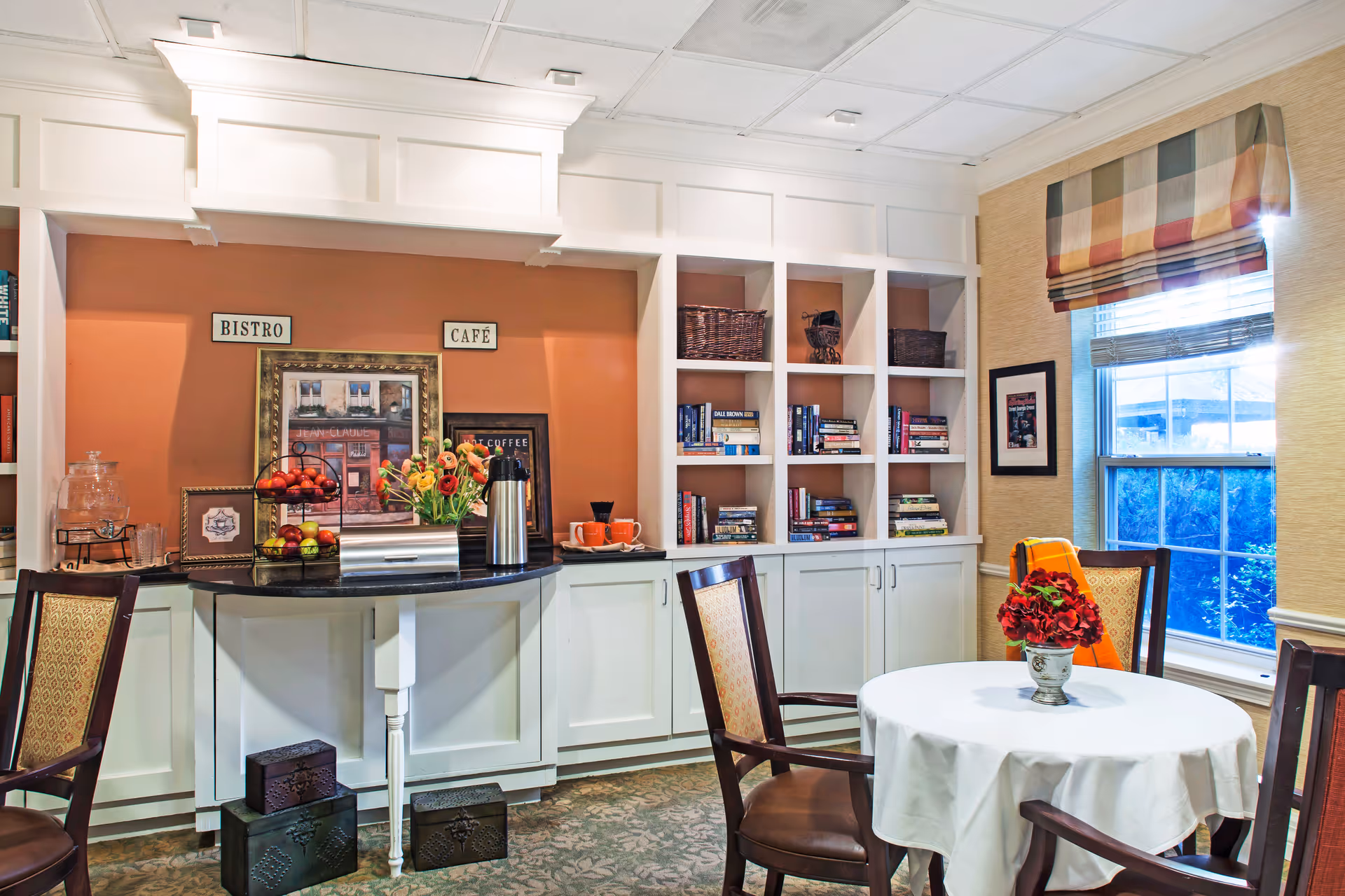 Brighton Gardens of Dunwoody: cozy dining lounge with built-in shelves, round table, and flowers.