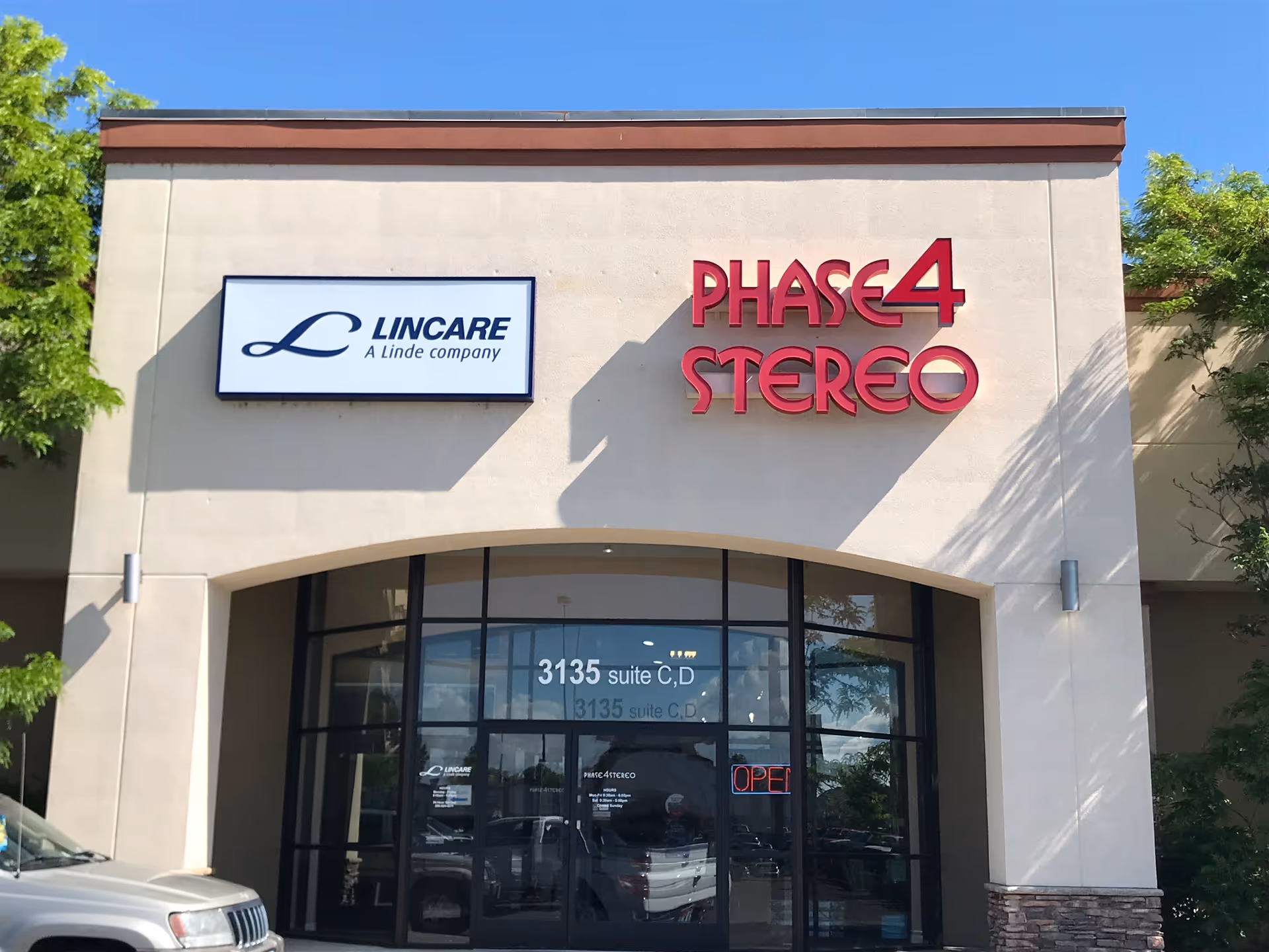 Exterior view of a building with Lincare sign and Phase4 Stereo storefront