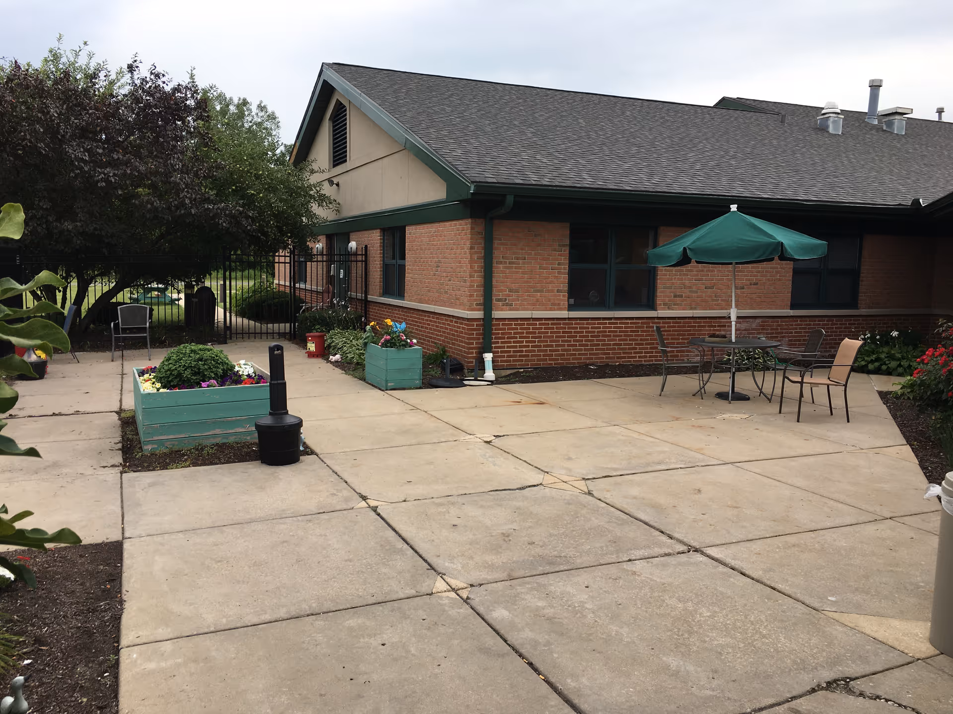 Exterior of The Pearl of St Charles: brick building, concrete patio, and outdoor seating area.