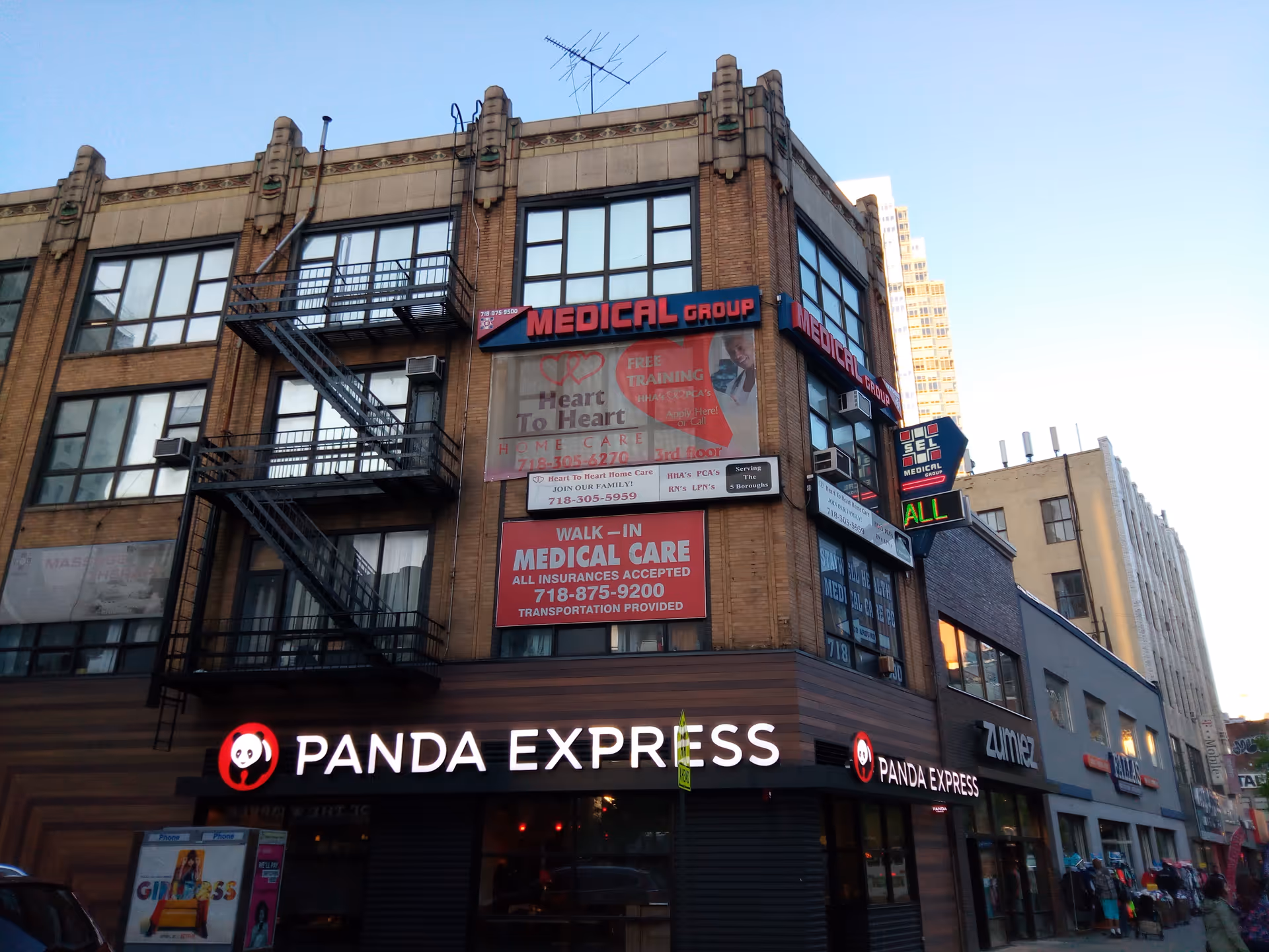 Urban brick building with multiple signs and a Panda Express storefront on the ground floor.