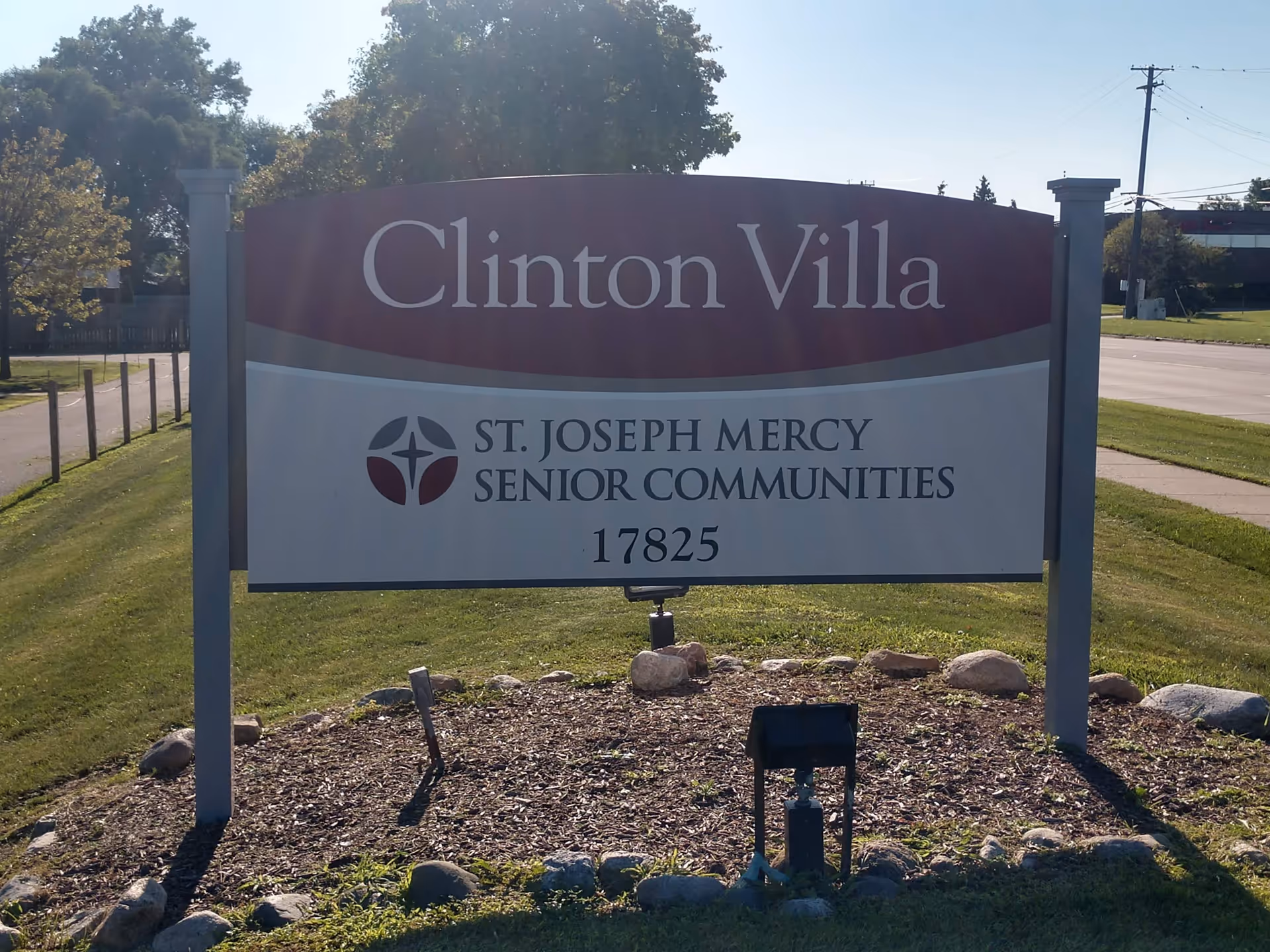 An exterior sign reads Clinton Villa for St. Joseph Mercy Senior Communities on a grassy lawn.