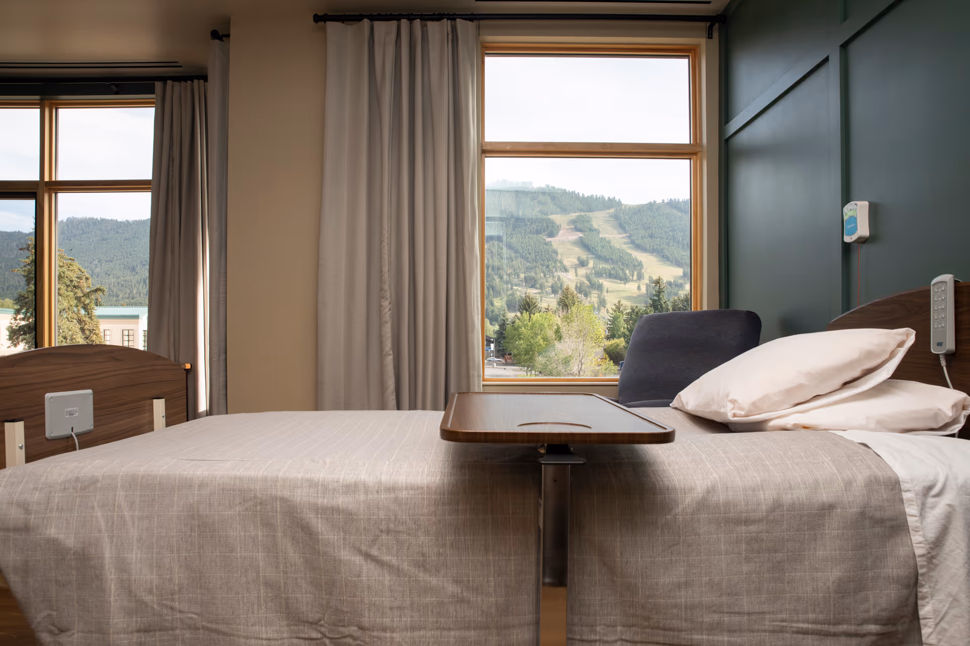 St. John's Living Center patient room with two beds, window view, and a central tray.
