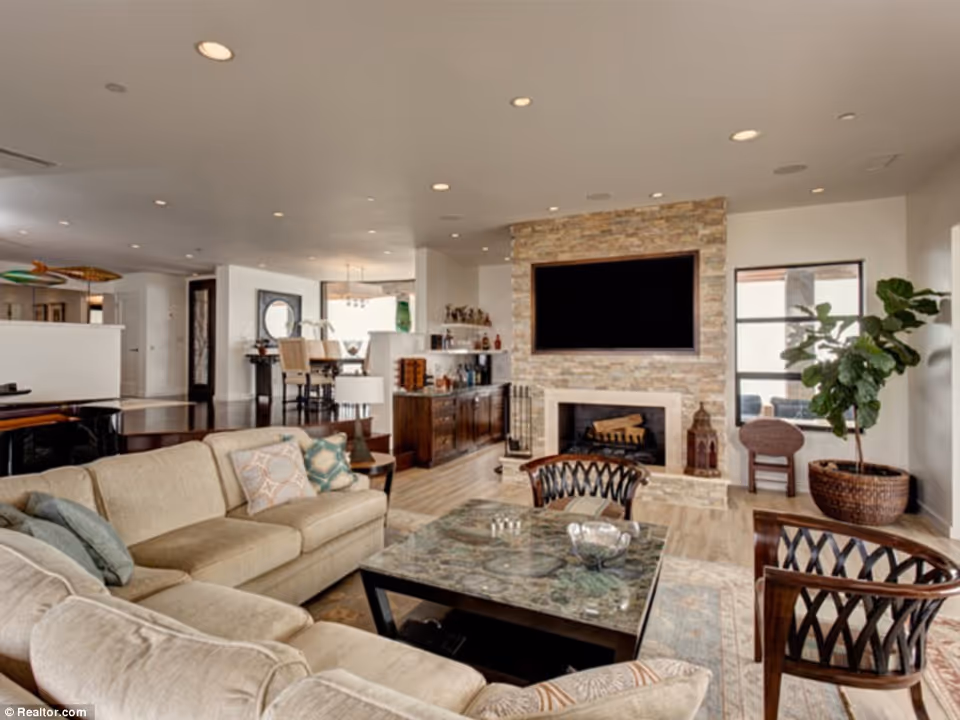 Spacious Mackenzie Manor living room with sofa, fireplace, TV, and seating.