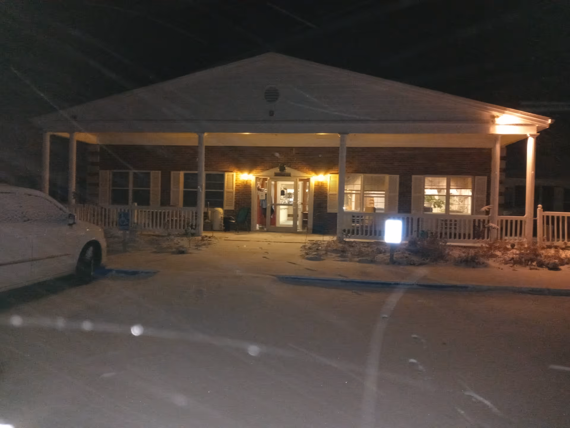 Night exterior of Ponderosa Villa with lit entrance and front porch.