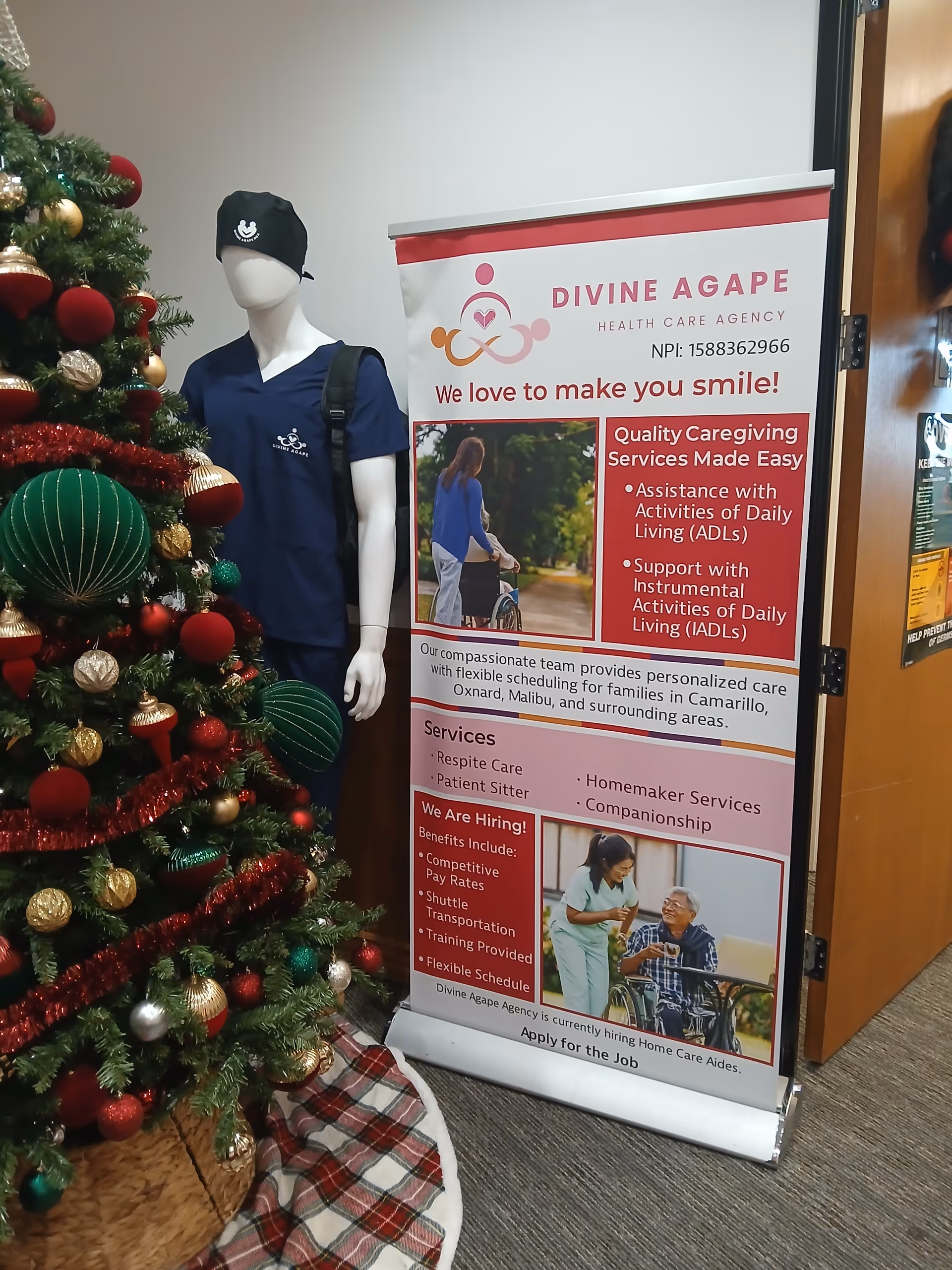 Christmas tree beside a Divine Agape Health Care Agency banner in an office hallway.