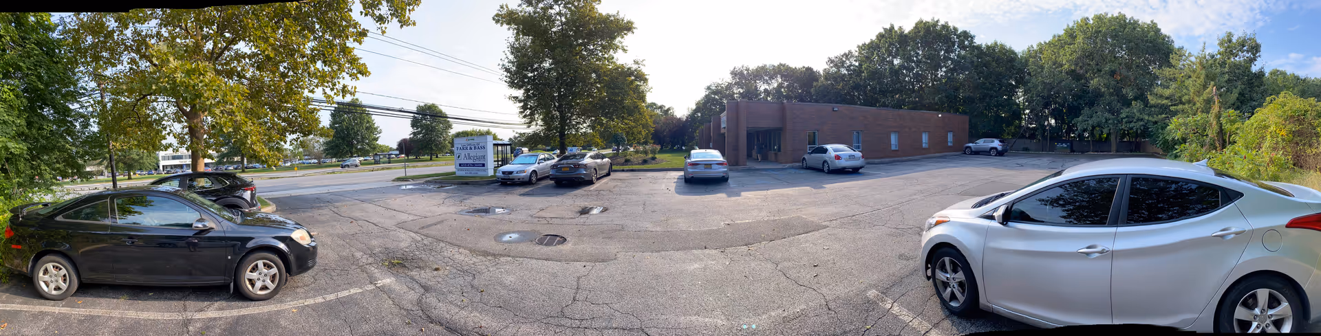 Parking lot in front of Allegiant Home Care building with several parked cars.