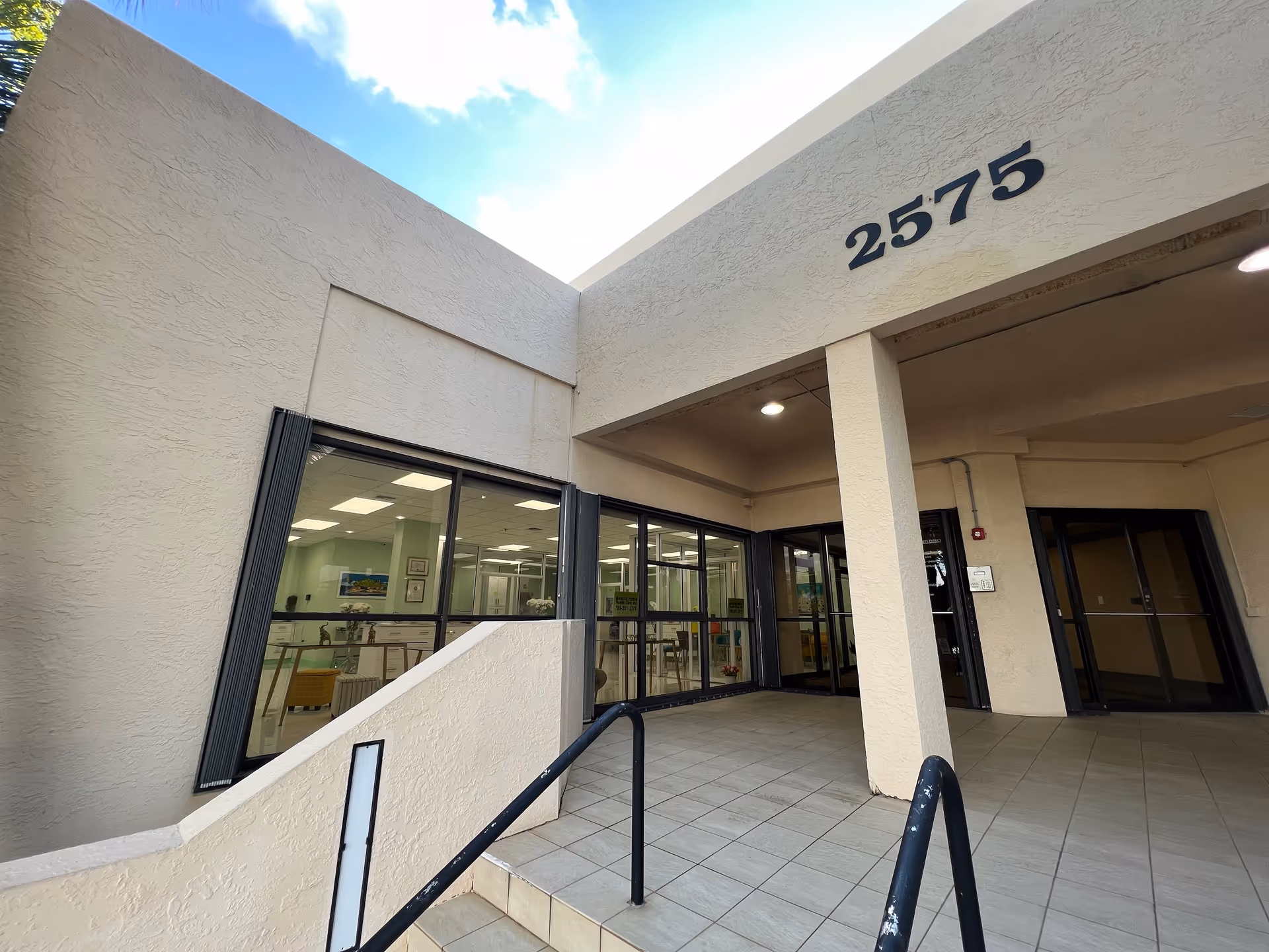Exterior view of Beatriz Home Health Care entrance with glass doors and ramp.