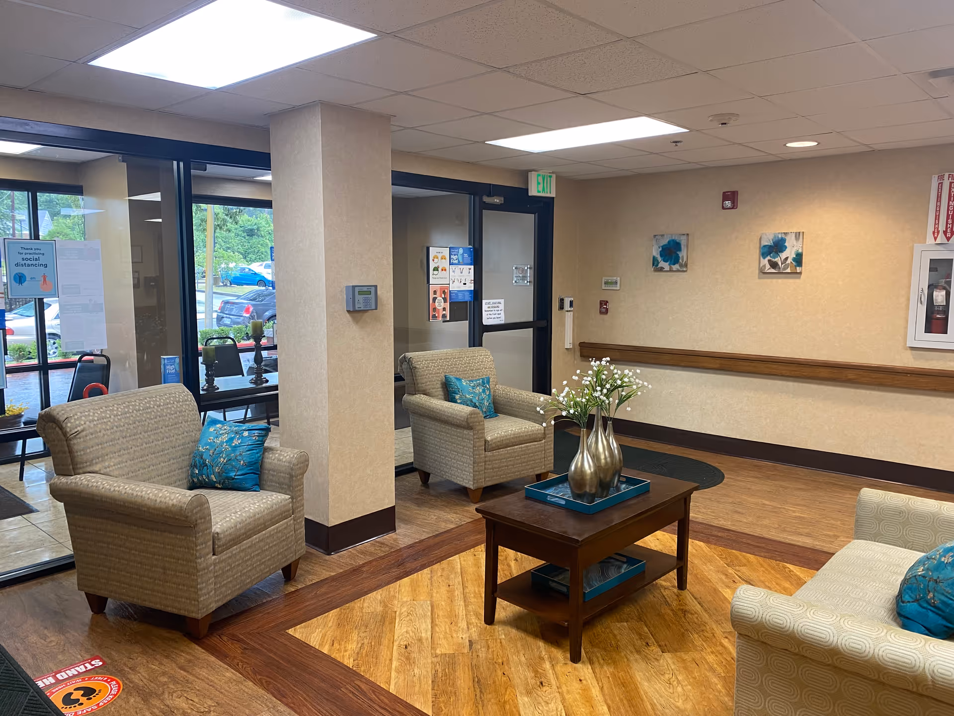 Lobby seating area with beige chairs, coffee table, and flower centerpiece.