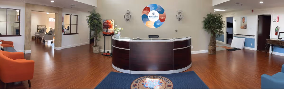 Lobby reception area with circular desk, wood floors, and lounge seating.