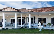 Front of Crescent Park Village showing a covered porch with white columns and outdoor seating.