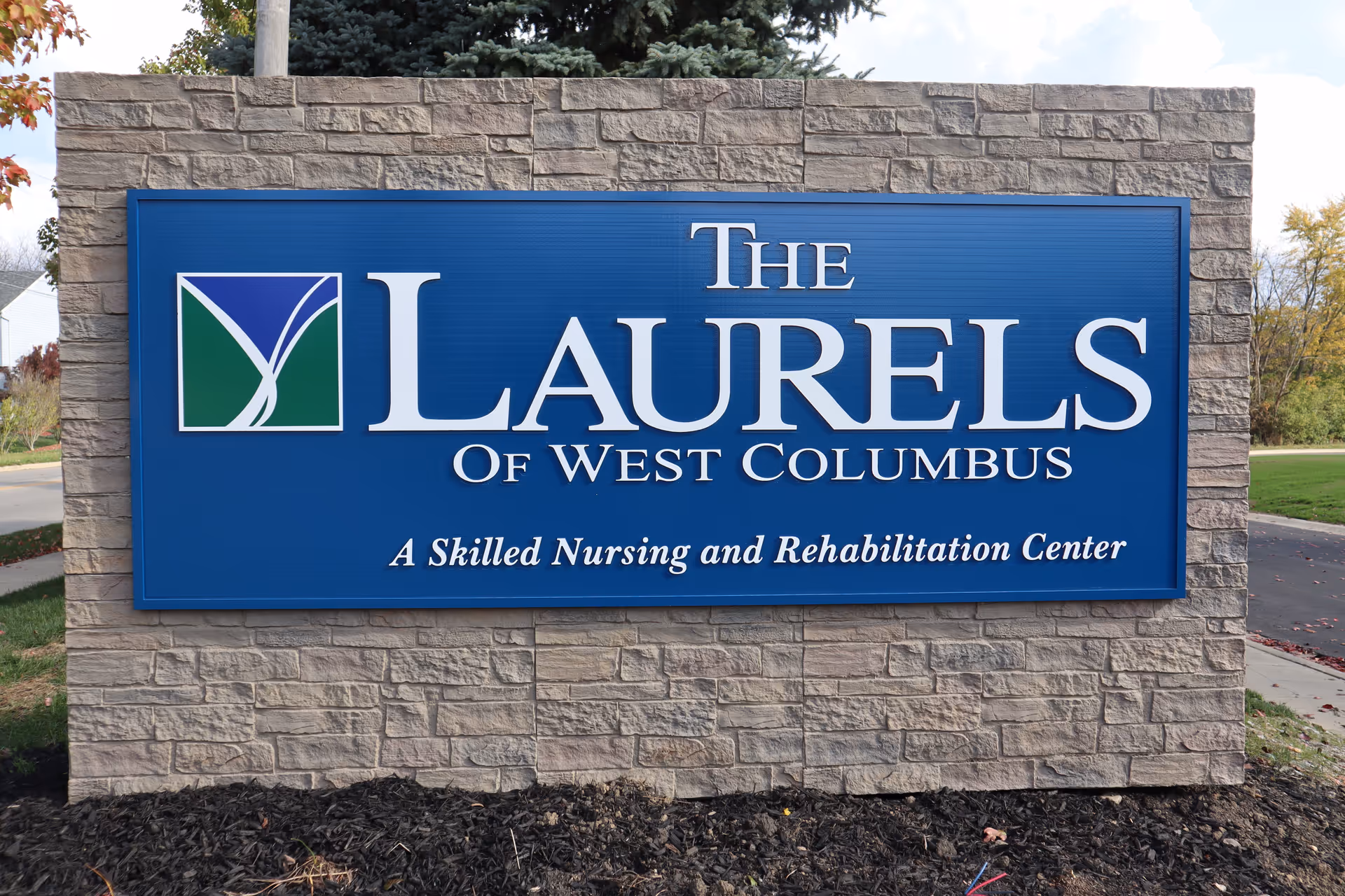 Blue stone monument sign that reads "The Laurels Of West Columbus: A Skilled Nursing and Rehabilitation Center."