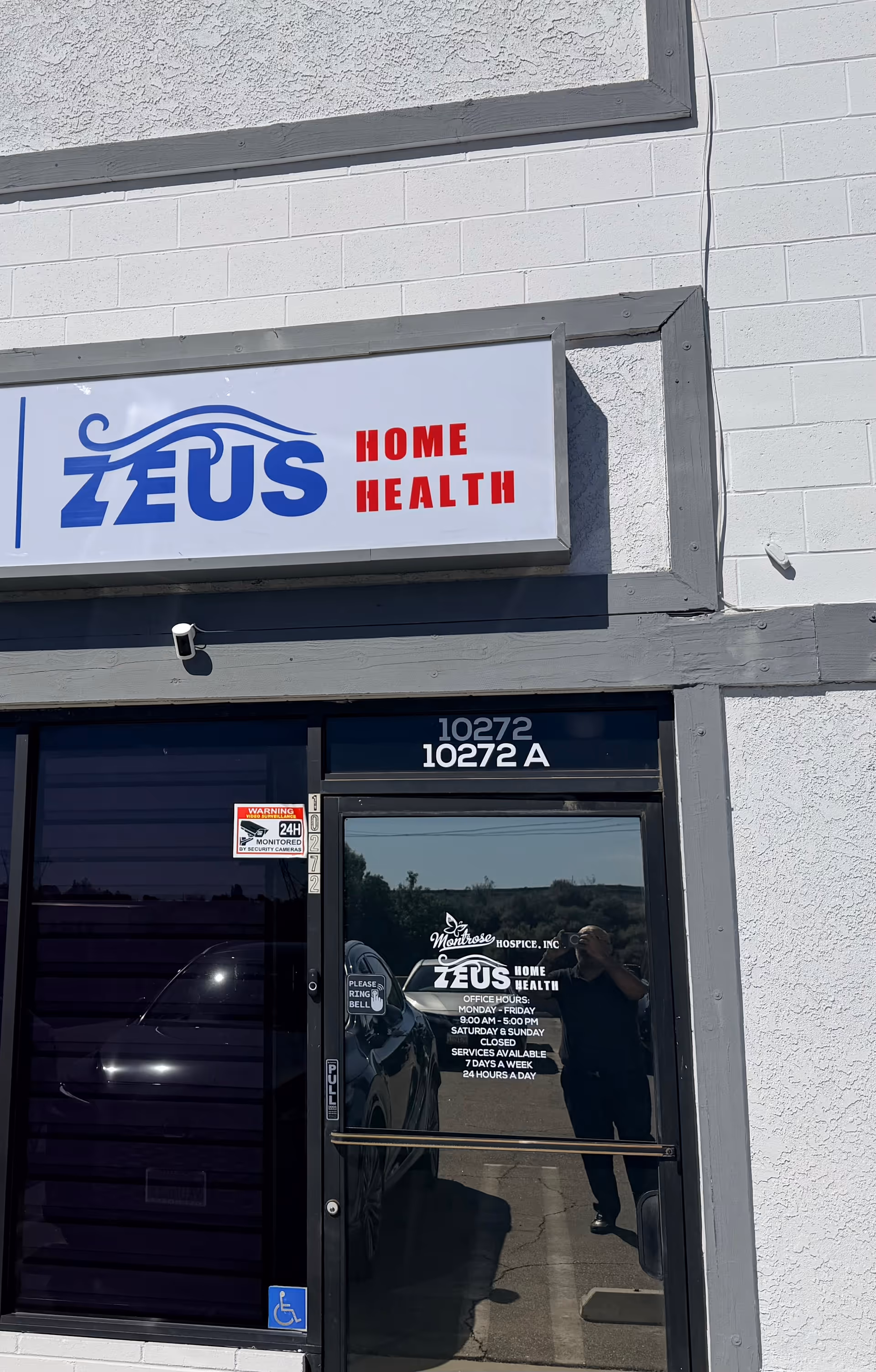 Exterior view of Zeus Home Health front entrance with sign on the building.