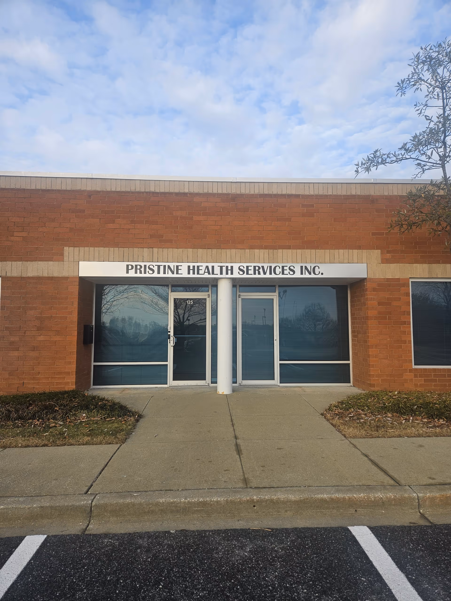 Brick exterior of Pristine Health Services Inc. with glass doors and storefront signage.