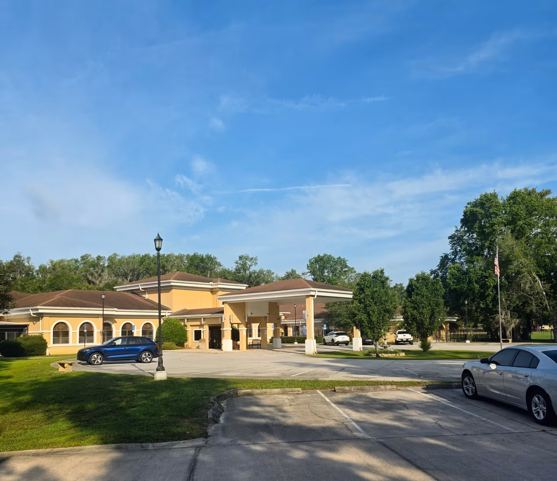 Exterior view of Cedar Hill Nursing and Rehab Center with entrance, driveway, and parked cars.