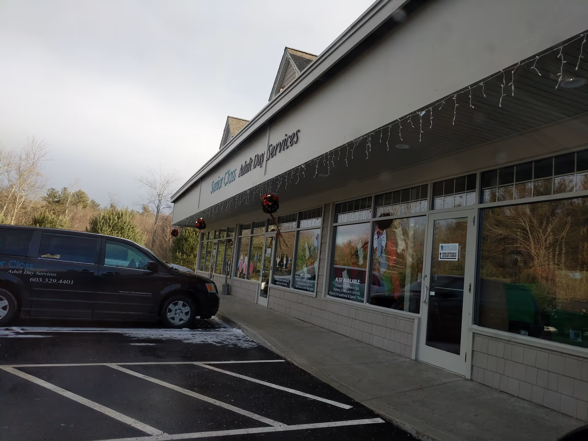 Exterior front view of Senior Class facility with glass storefront and a parked van.