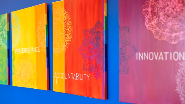 Colorful wall panels with inspirational words on a blue interior wall.