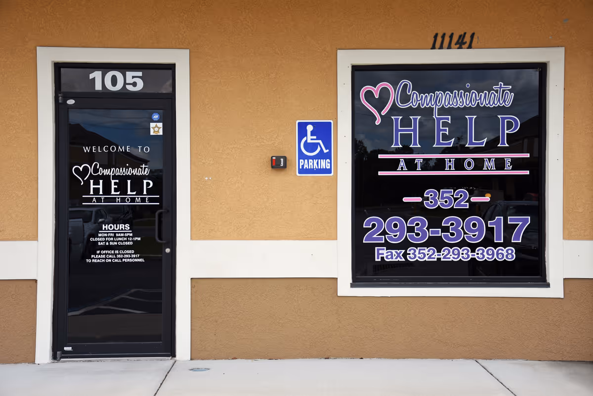 Exterior of a building with door 105 and a large Compassionate Help at Home window sign.