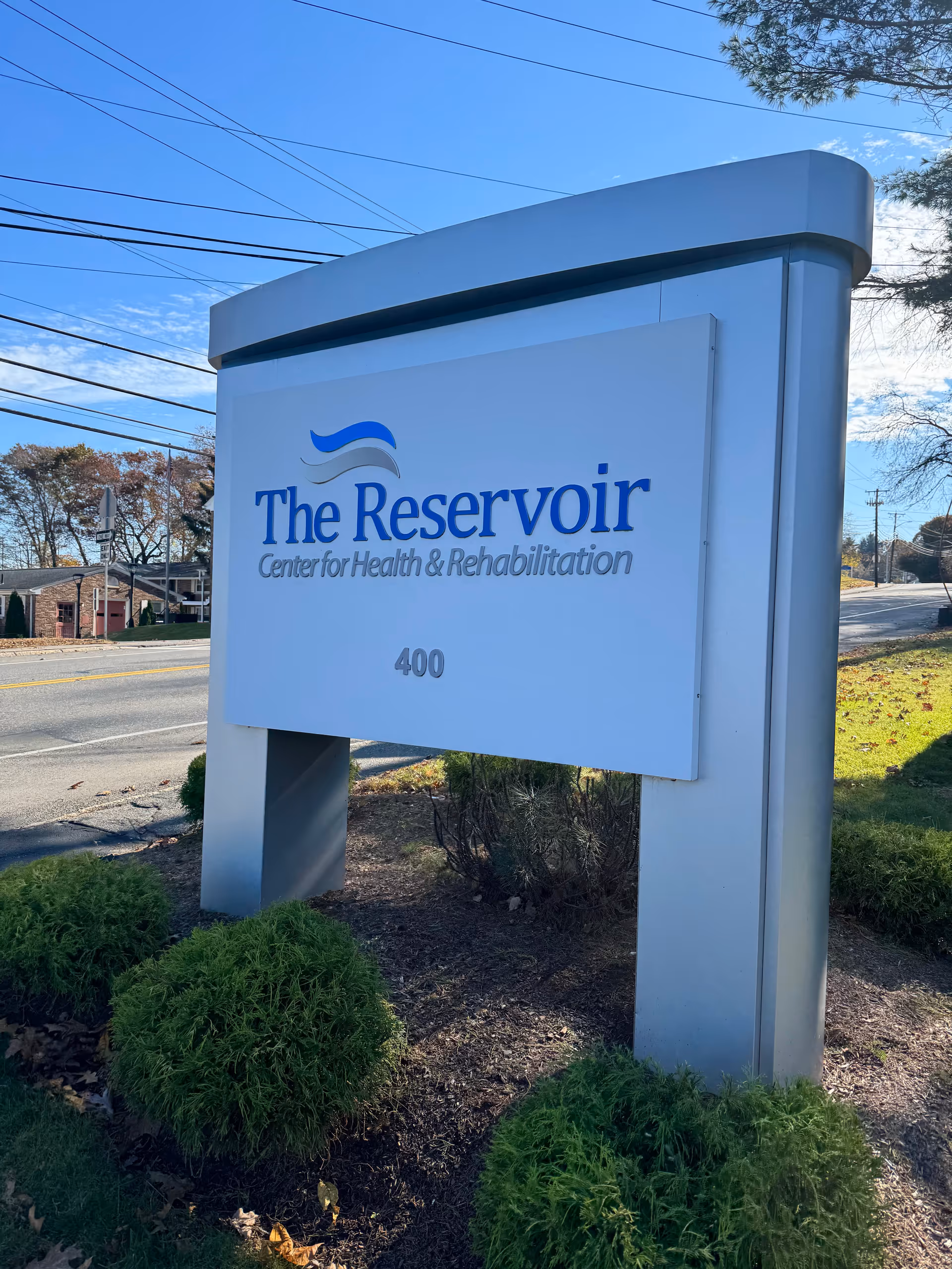 Exterior view of The Reservoir Center for Health & Rehabilitation sign by the road.