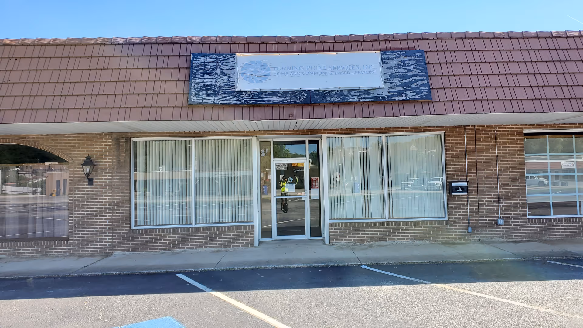 Exterior of Turning Point Services, Inc. building with brick facade, large windows, and glass entrance.