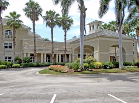 Exterior view of Brookdale Bonita Springs senior living facility with palm trees.
