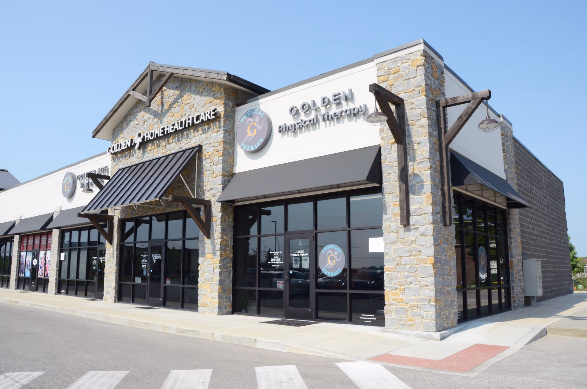 Exterior view of a stone building with Golden Physical Therapy signage.