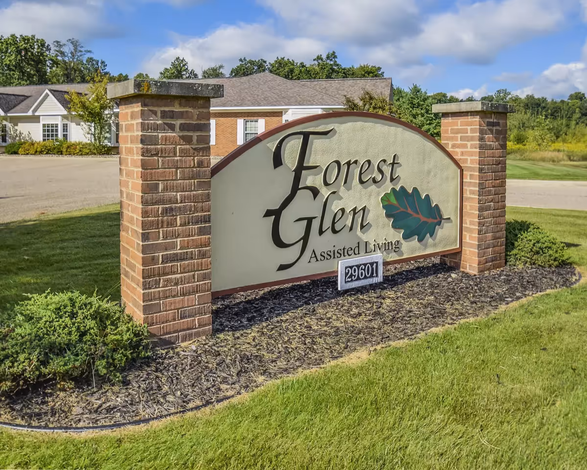 Forest Glen Assisted Living entrance sign with brick pillars and landscaped front yard.