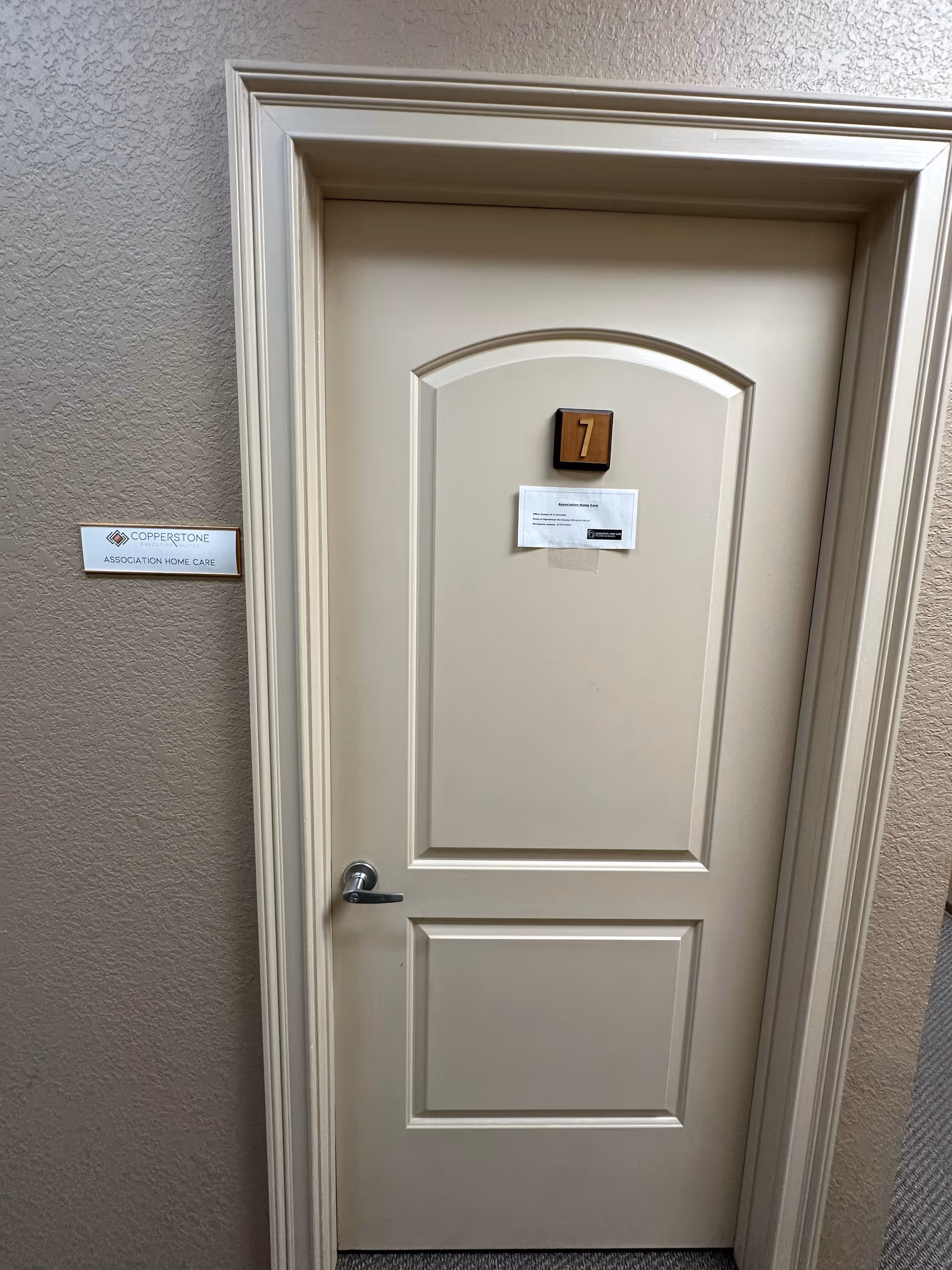 Interior hallway with a beige door labeled 7 in a senior care facility.