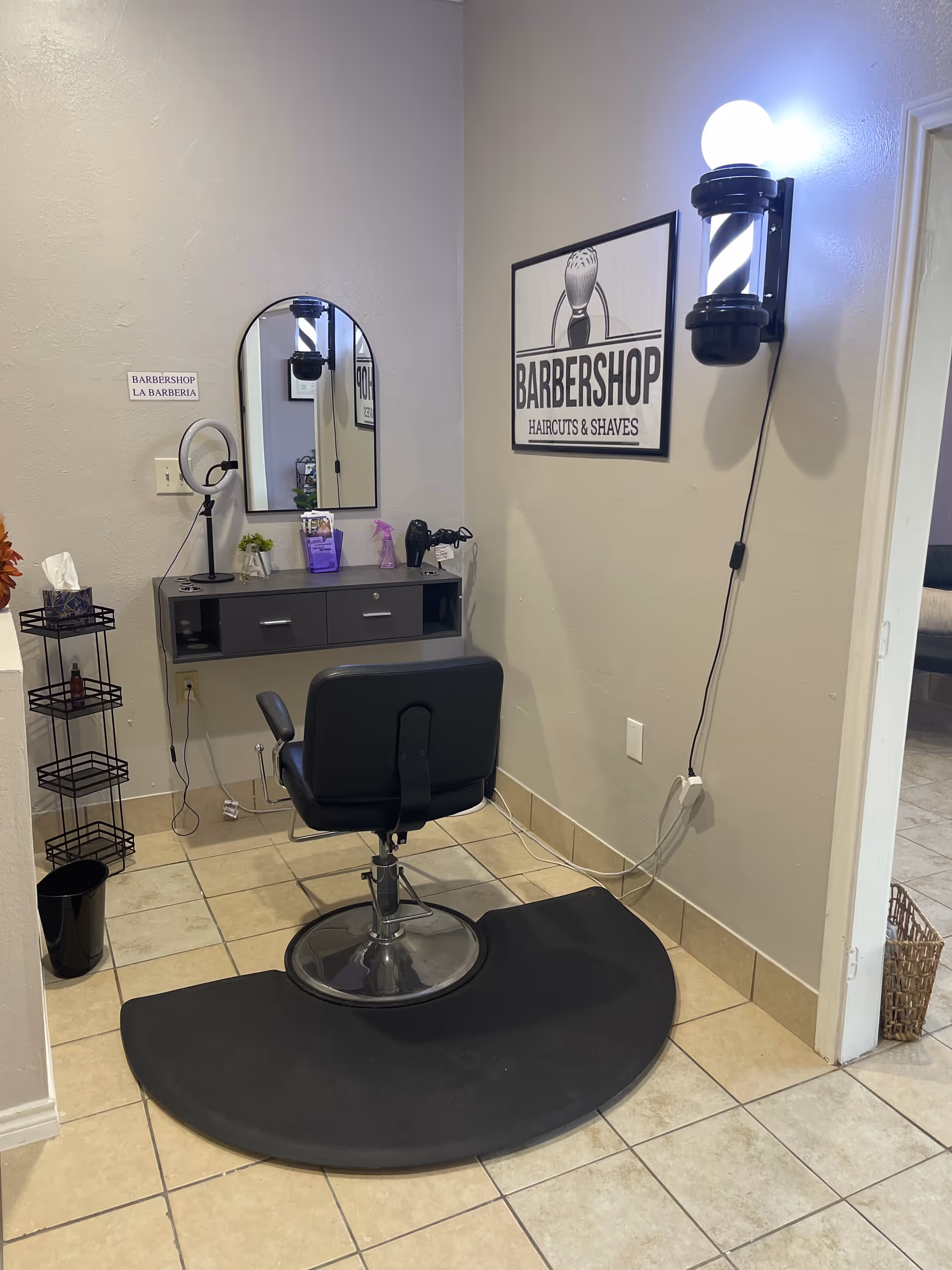 Interior barber station with chair, mirror, and Barbershop sign in senior living facility.