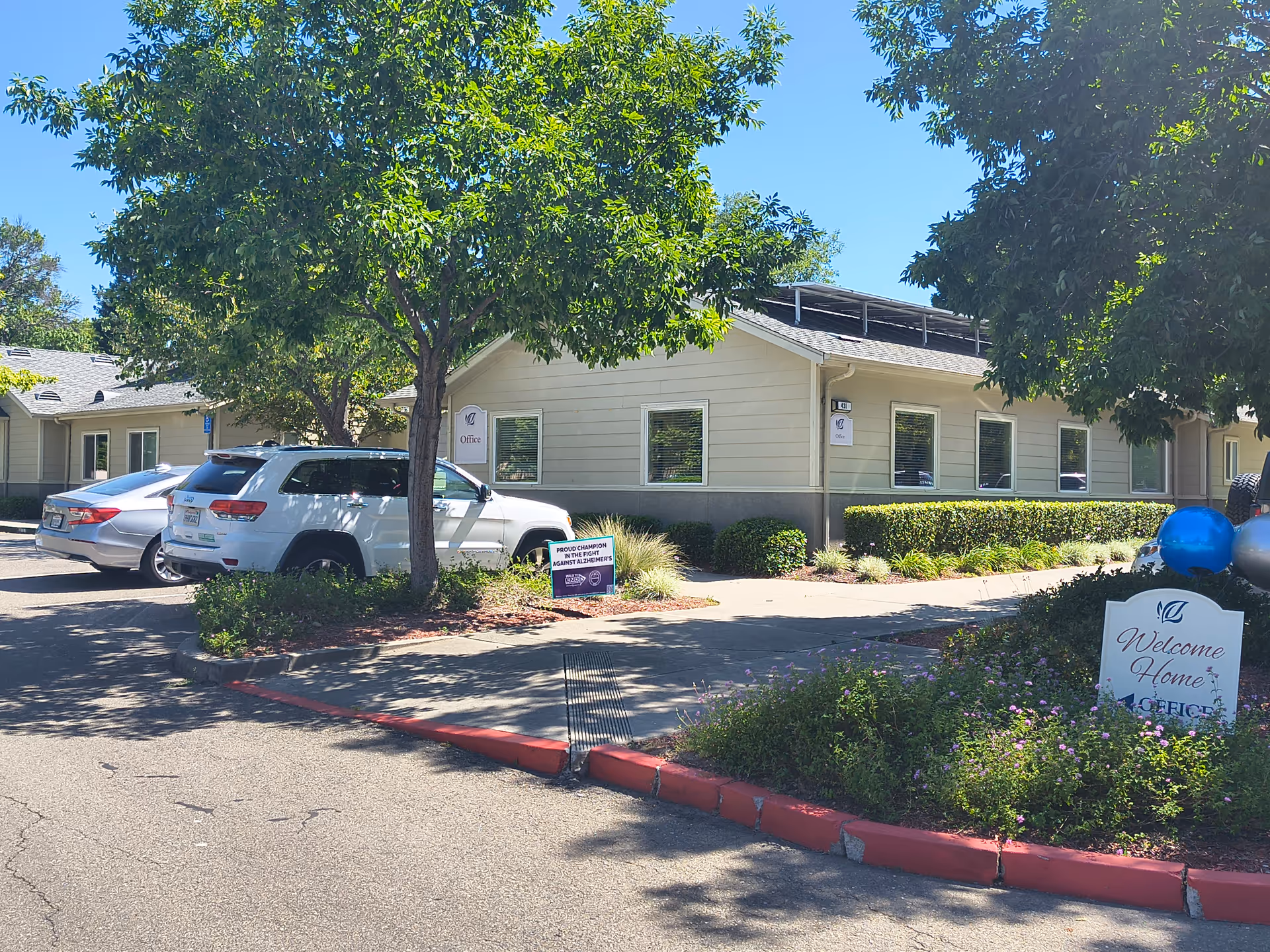Exterior view of Vacaville Memory Care building with cars parked nearby.