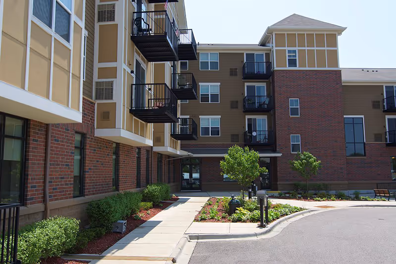 Exterior view of Specialty Home Care building with brick facade, balconies, and landscaped entrance.