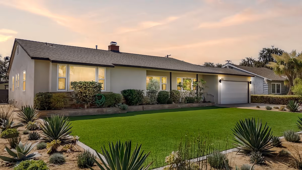 Front of a single-story care facility with a manicured lawn and shrubs.