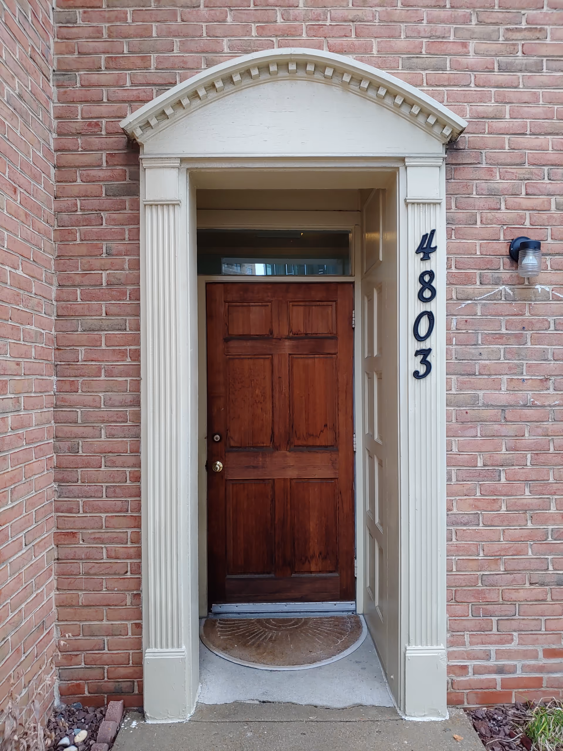 Front entrance of Visiting Angels Senior Home Care Bethesda with brick walls, arched pediment, and 4803.