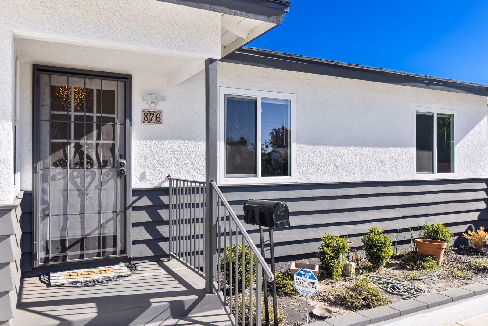 Exterior of Era Life Home facility, entrance with security door and small garden.