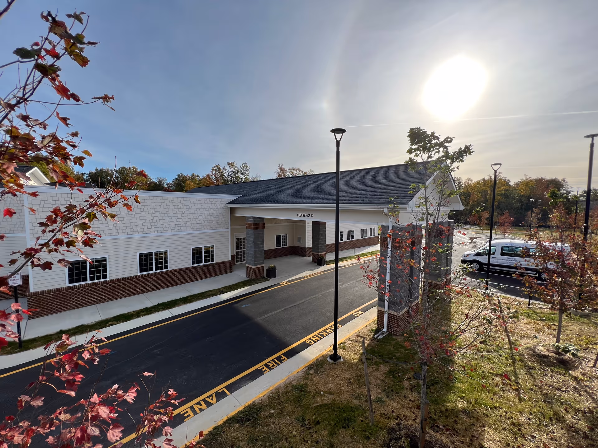 Senior living facility exterior with covered entrance and a parked van