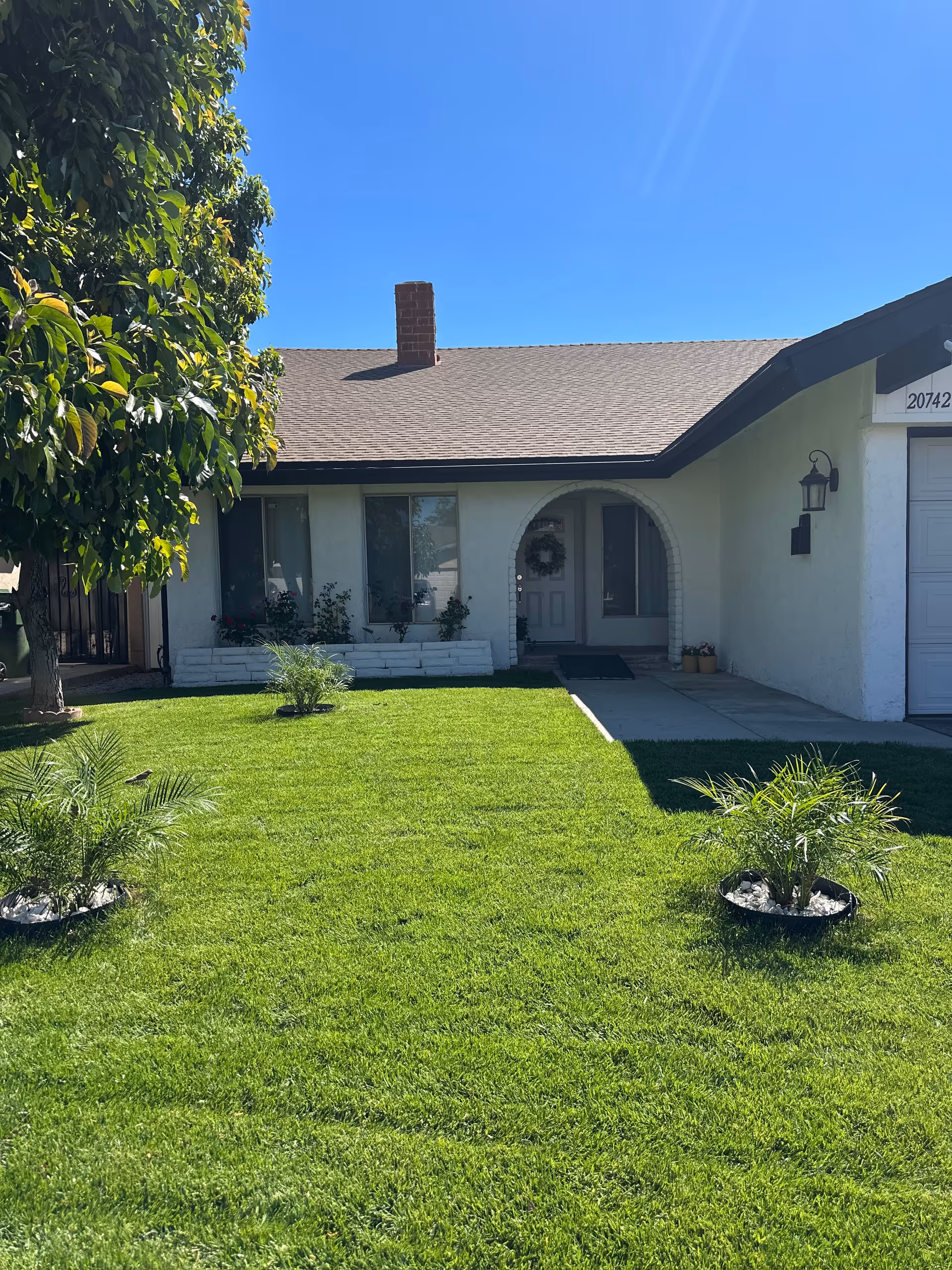 Front view of a single-story senior living home with a green lawn and entrance.