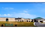 Exterior view of Zephyr Loving Care facility with stone walls and a covered entrance.
