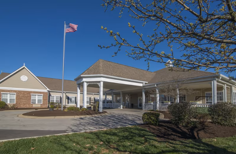 Exterior view of Crescent Place Assisted Living entrance with covered drop-off area.