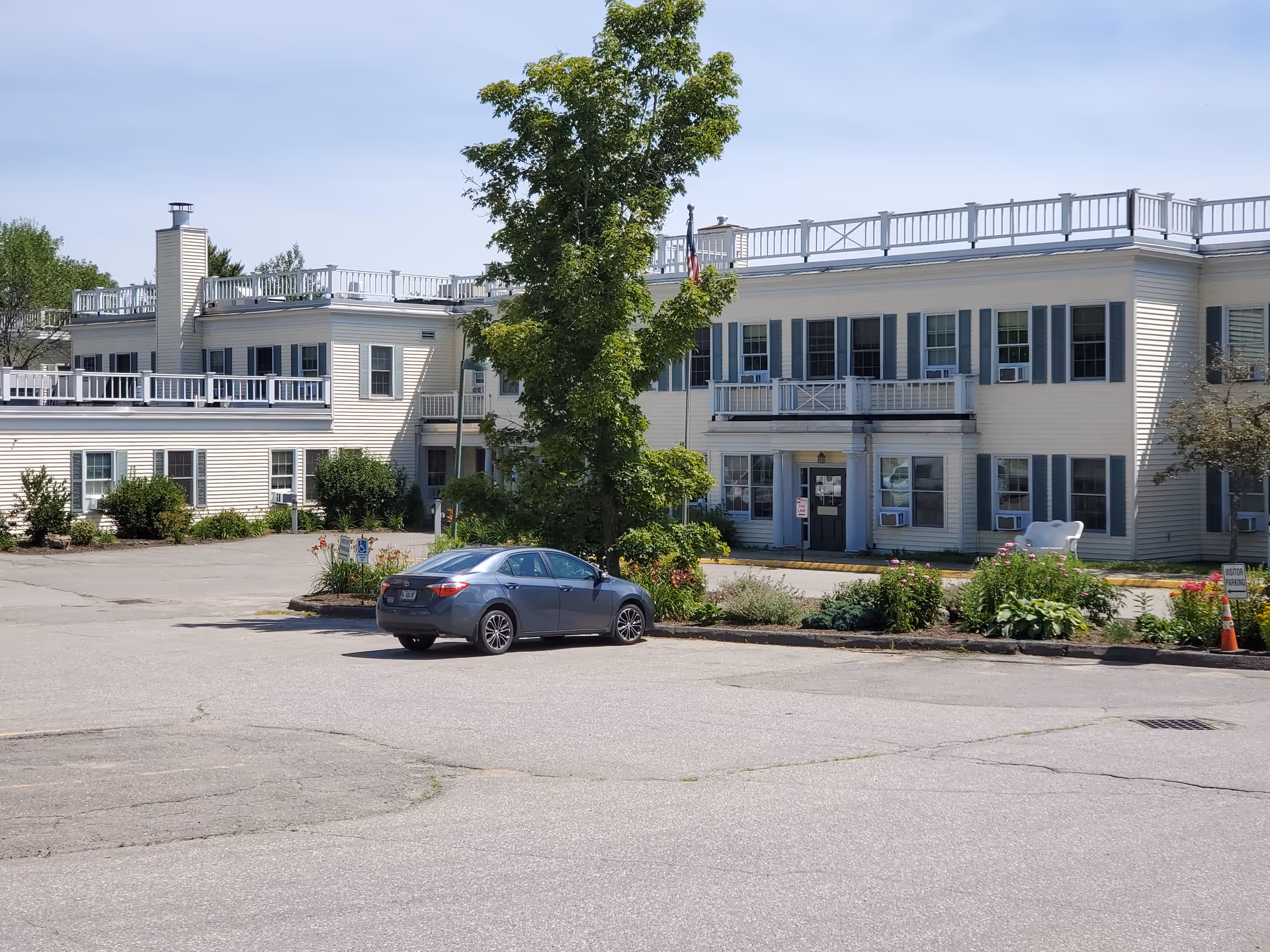 Harbor Hill Center front exterior: two-story light siding building with parking and landscaping.