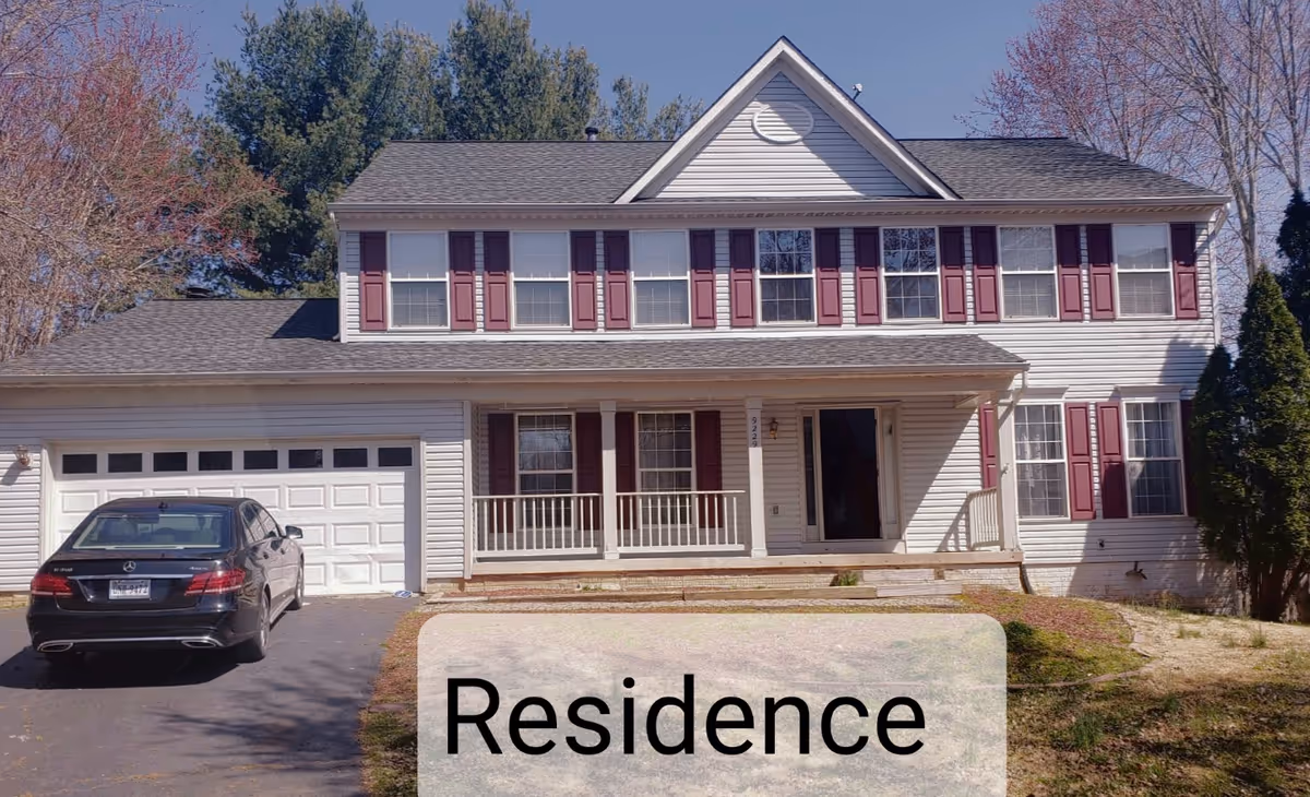 Two-story suburban residence with a garage, front porch, and maroon shutters.
