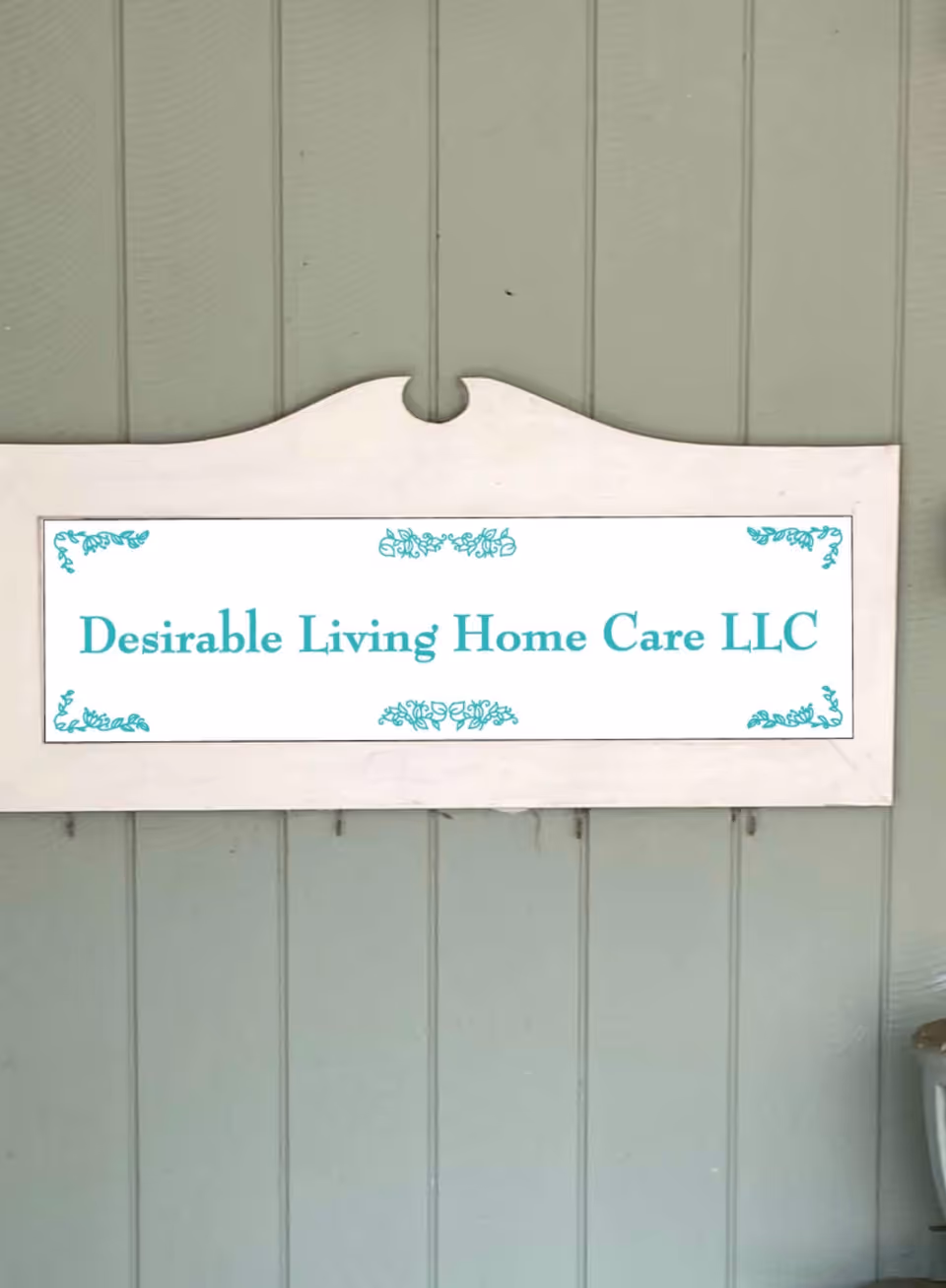 Exterior wall with a white sign reading Desirable Living Home Care LLC.