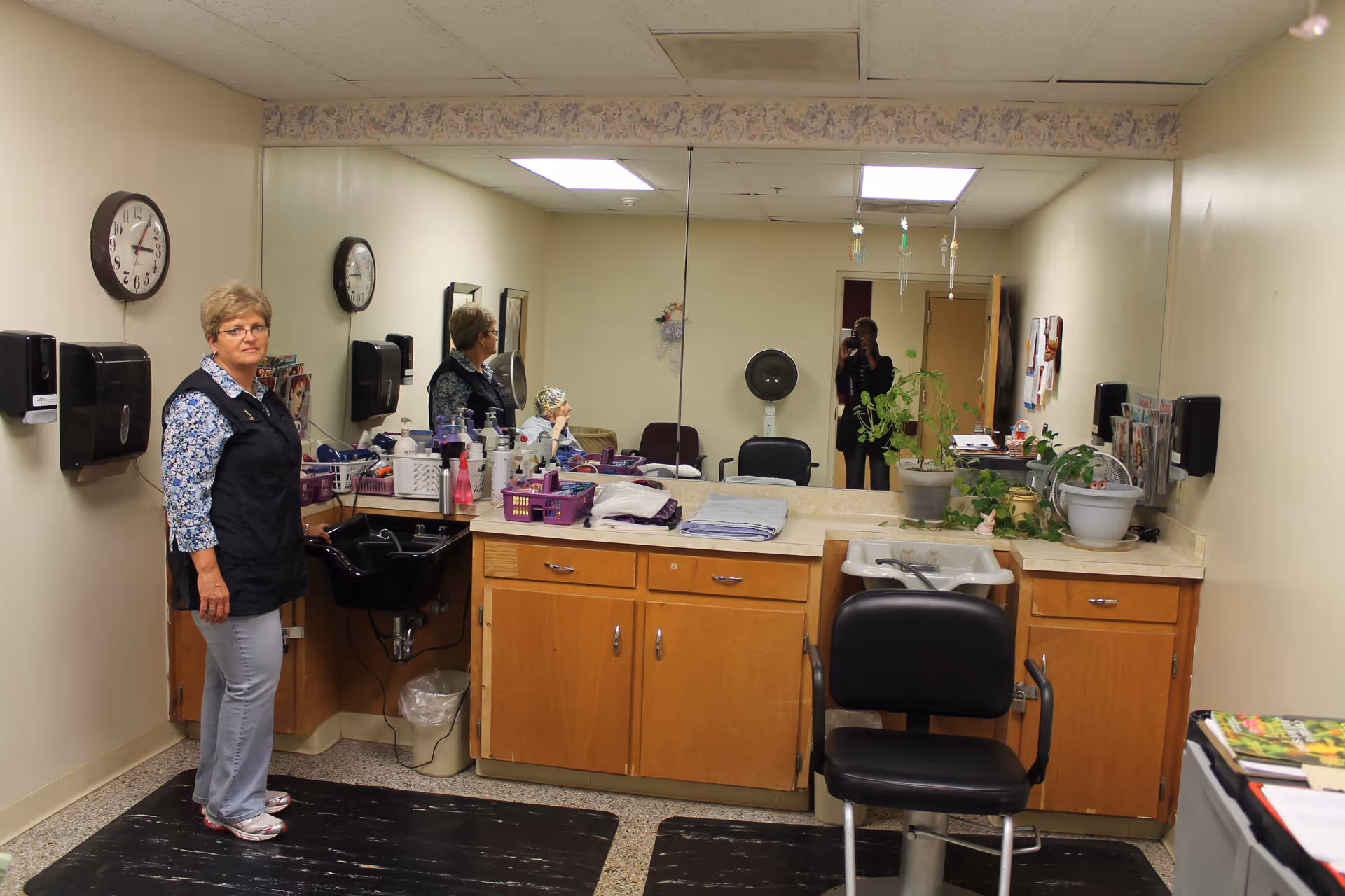 Staff member stands at a salon station inside Magnolia Manor interior.