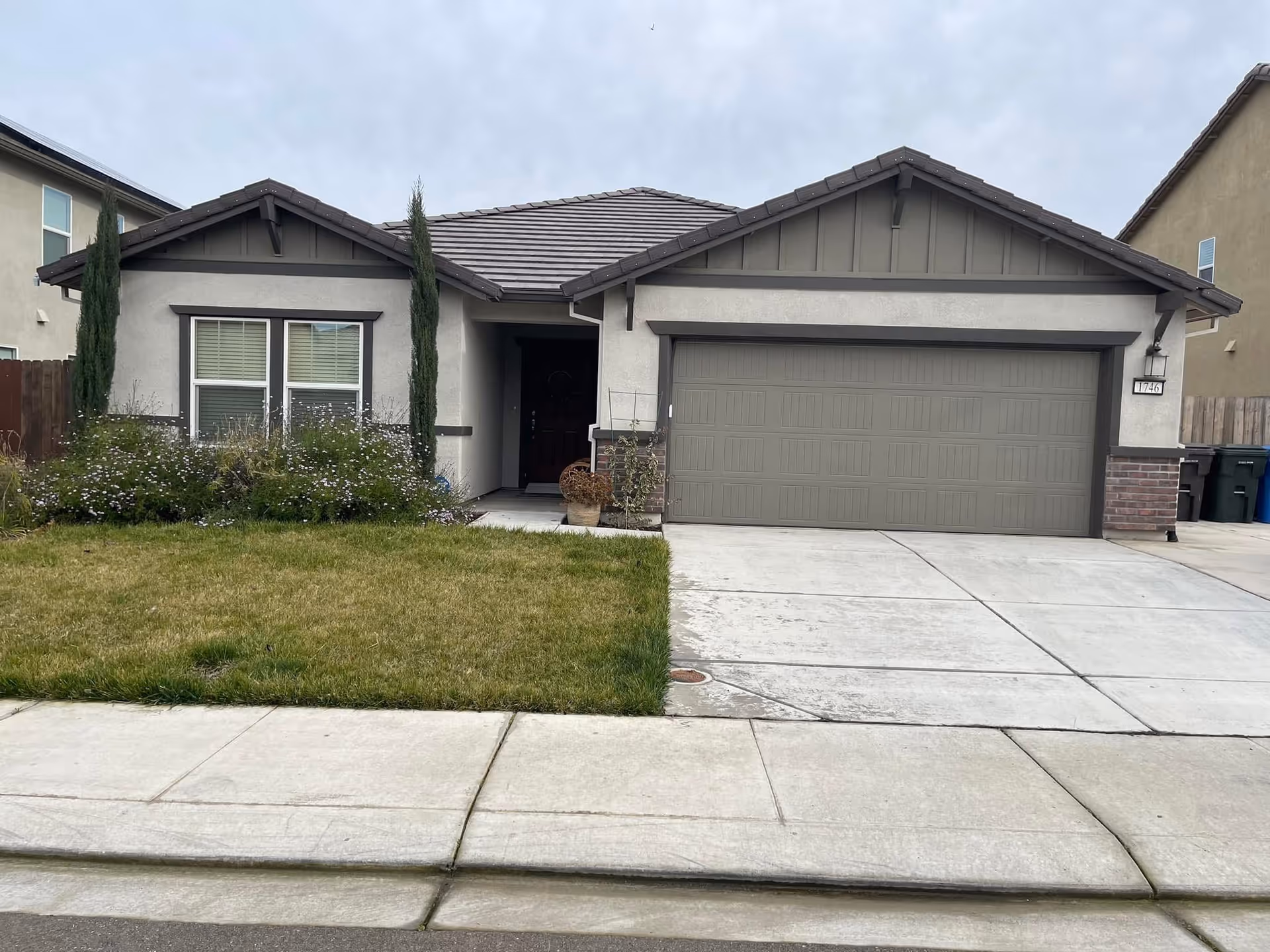Front view of a single-story home with a two-car garage and front lawn.