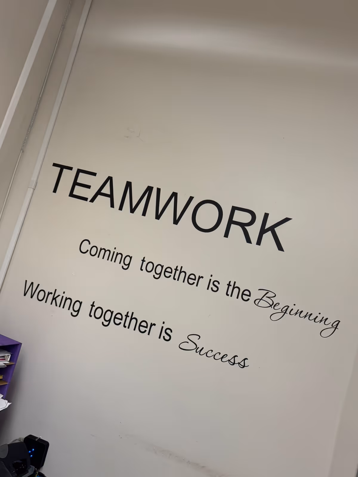 Interior wall featuring large TEAMWORK text and motivational quotes.
