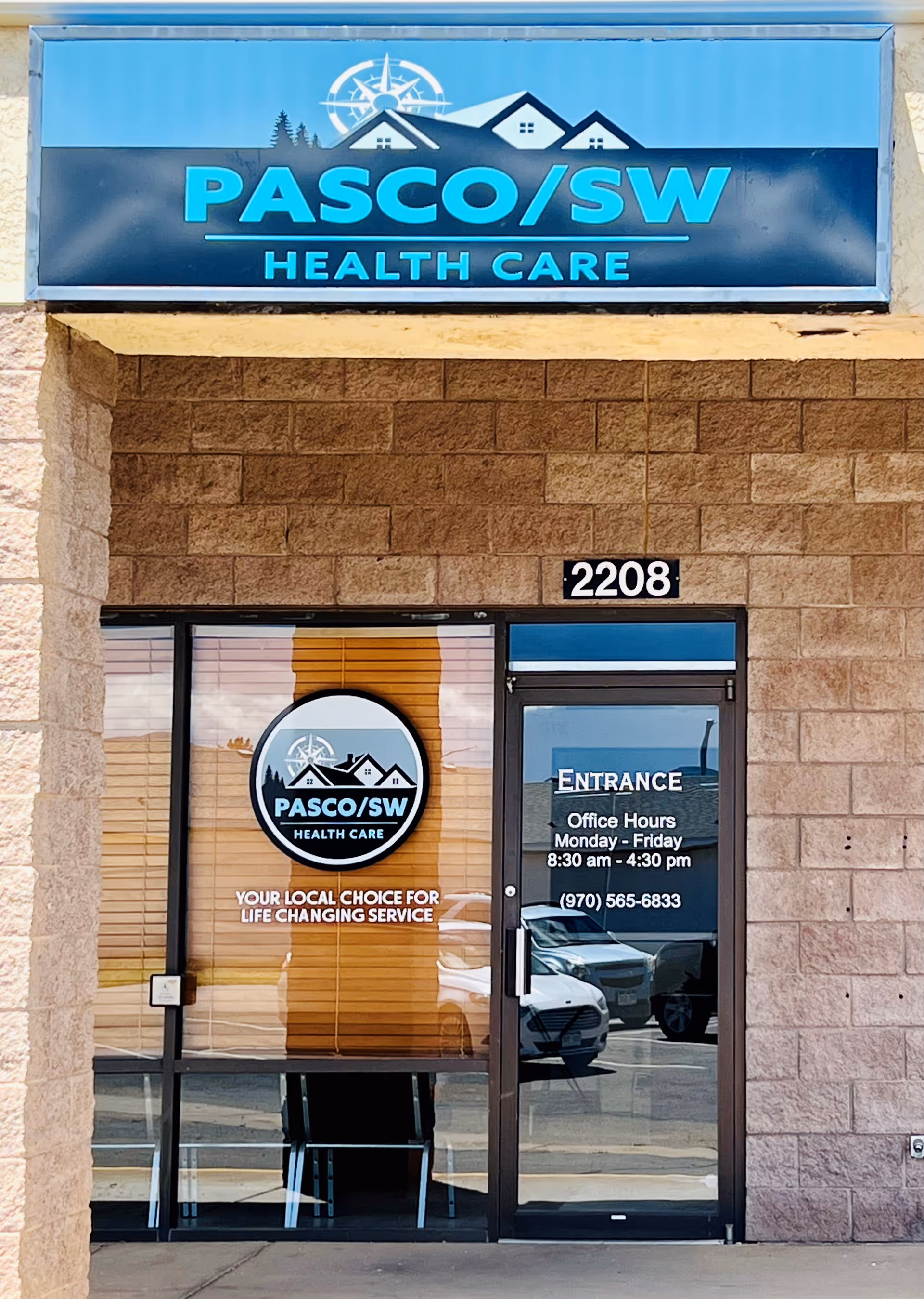 Facade of PASCO/SW Health Care building with sign and entrance door.