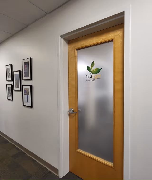 Hallway with frosted glass door featuring FirstLight Home Care logo.